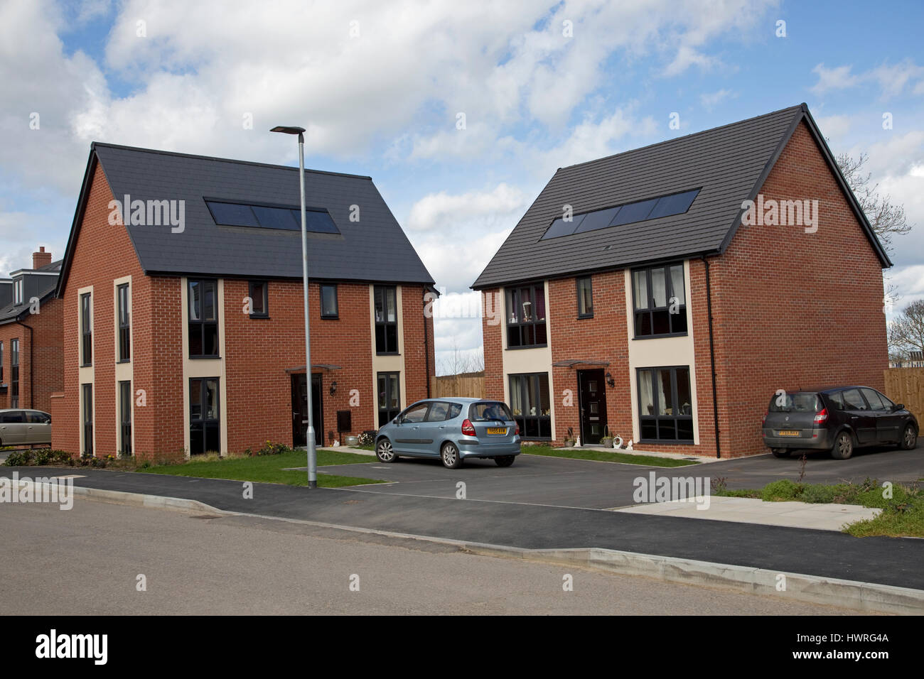 Neuen roten Backsteinhäuser mit solar Schwarz pv Panels persimmon greenacres Bishops Cleeve Cheltenham uk Stockfoto