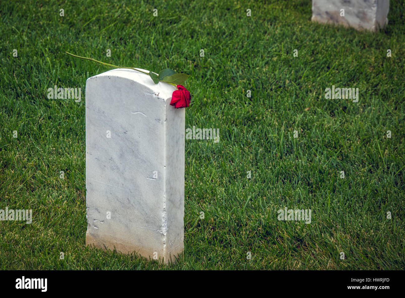 Am Tag nach dem Memorial Day 2016 auf einem südlichen California Militärfriedhof, die Rückseite eines Grabes mit einer Rose ruht an der Spitze. Stockfoto