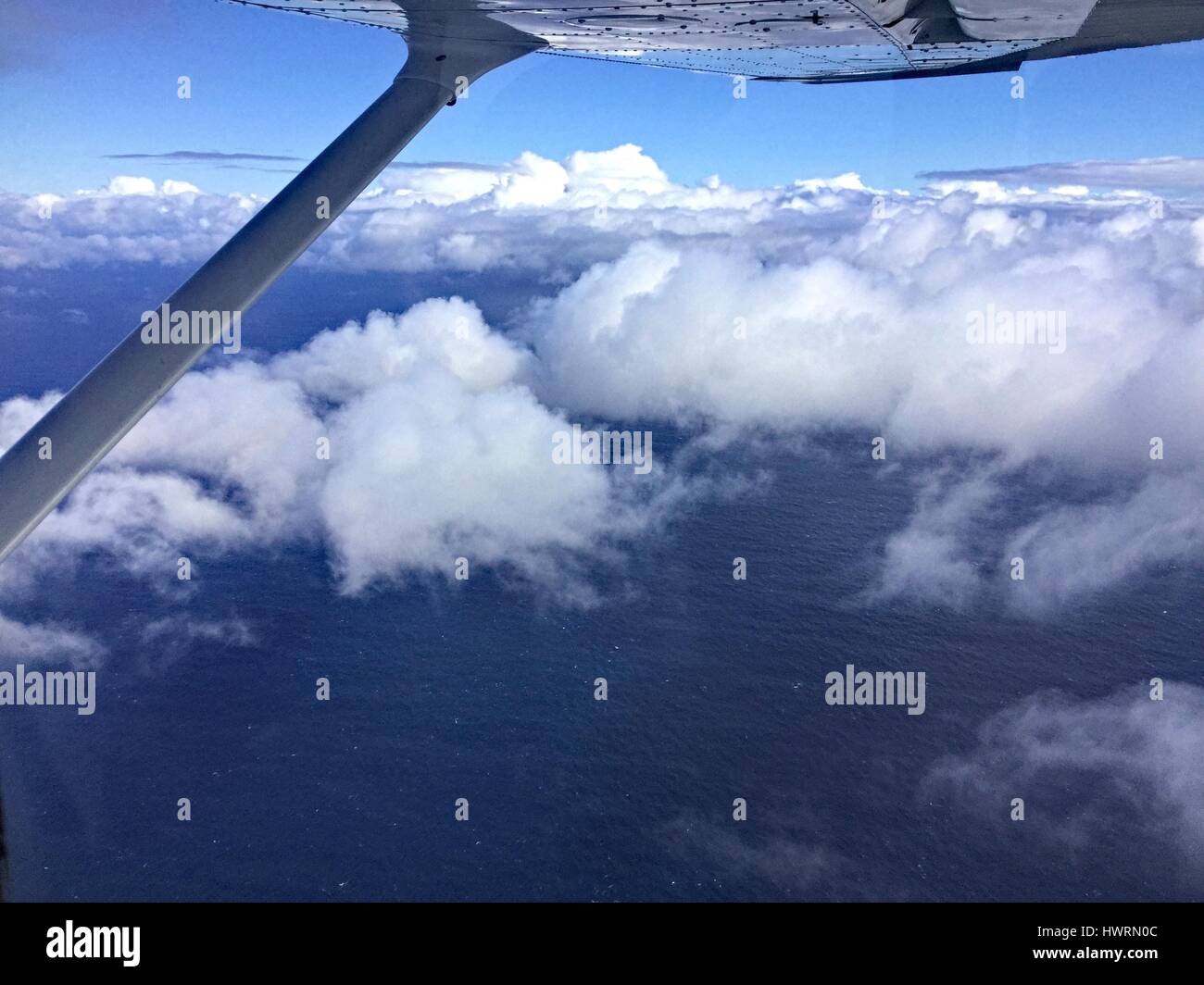 Blick aus dem Fenster eines leichten Flugzeug fliegen über den Wolken über dem Ozean. Stockfoto