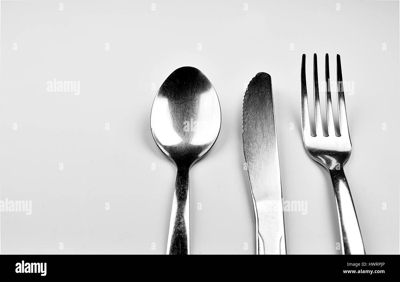 Löffel, Messer und Gabel auf grauem Hintergrund isoliert Stockfoto