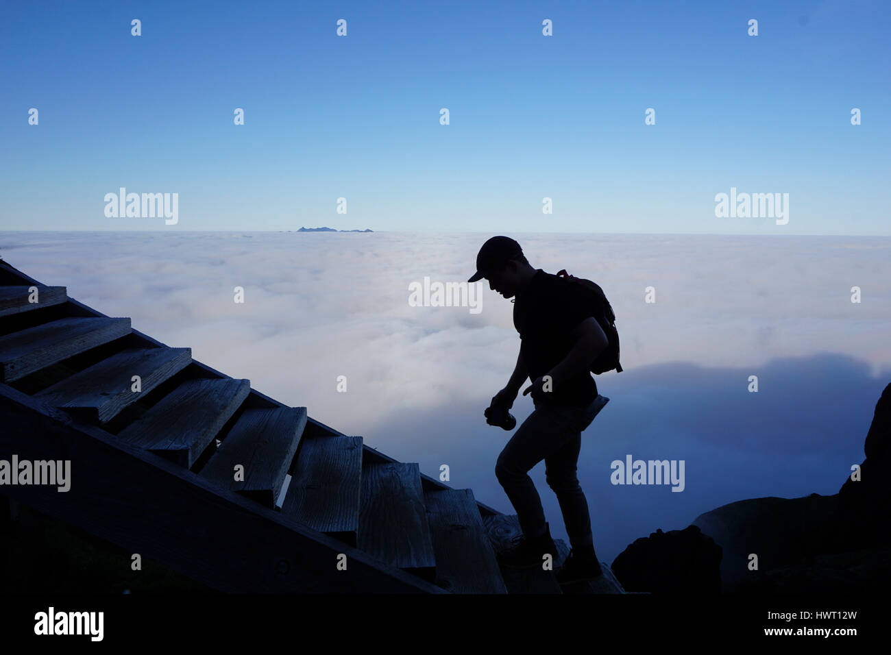 Silhouette männliche Wanderer bewegt sich Schritte durch Wolkengebilde Stockfoto