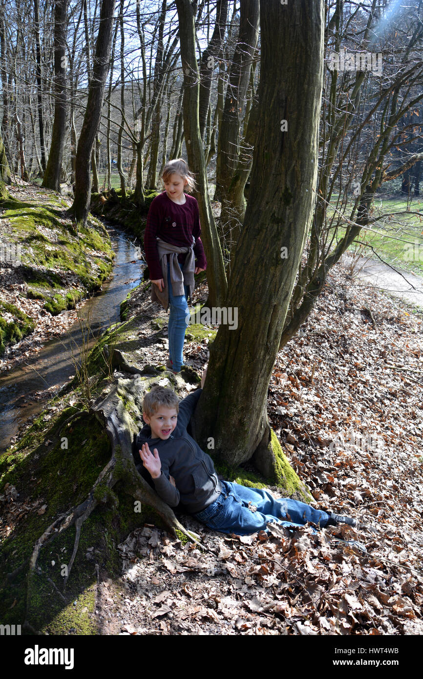 Zwei Kinder spielen in einem kleinen Bach im Wald Stockfoto