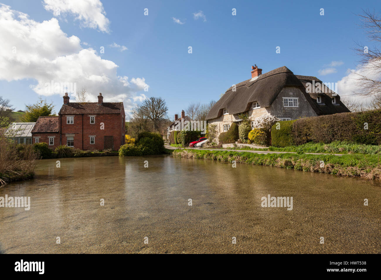 Ferienhäuser rund um den Teich in dem hübschen Dorf Sherrington, Wiltshire, England, Großbritannien Stockfoto