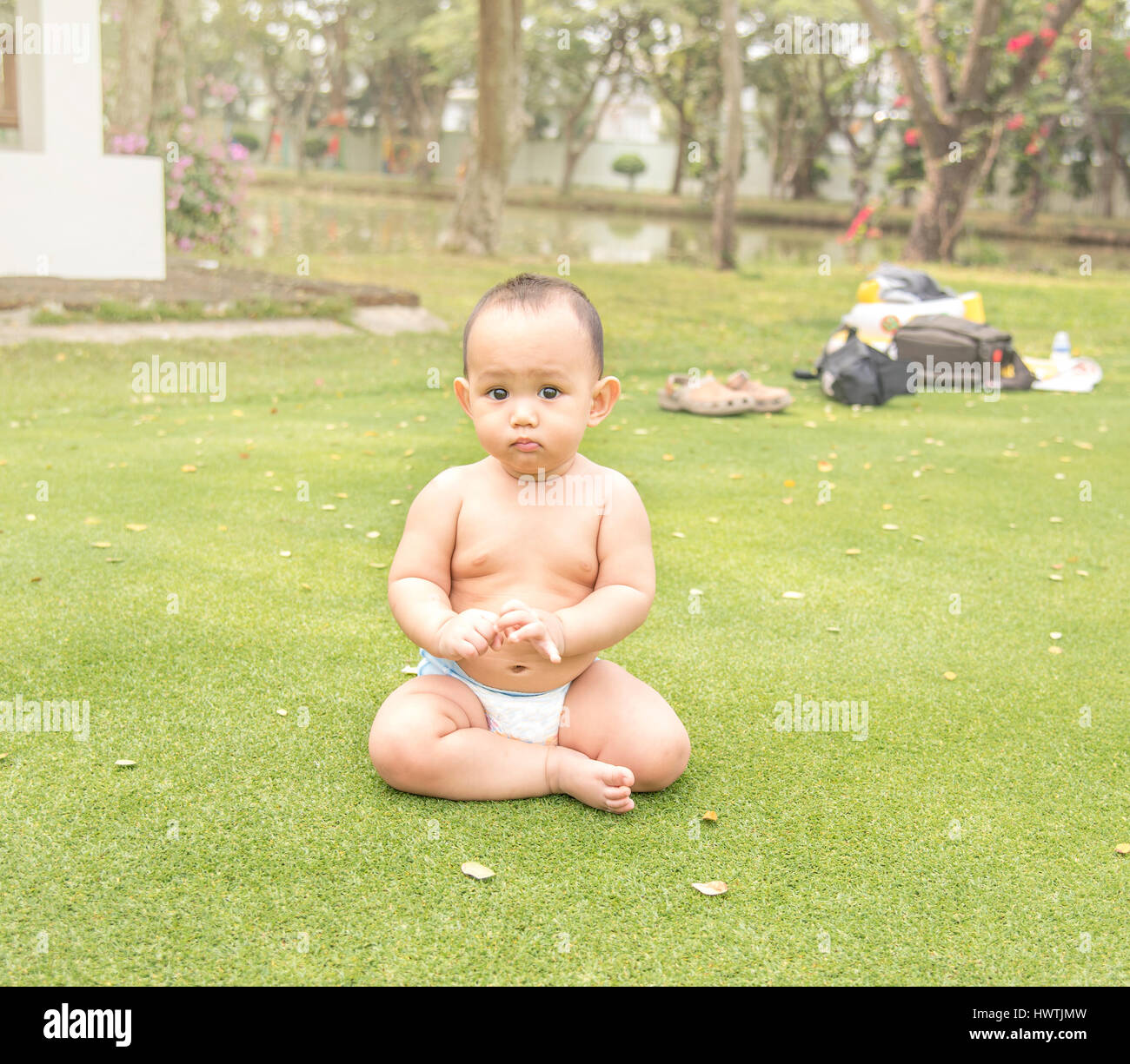 gesundes Baby sitzt auf der grünen Wiese im Outdoor-park Stockfoto