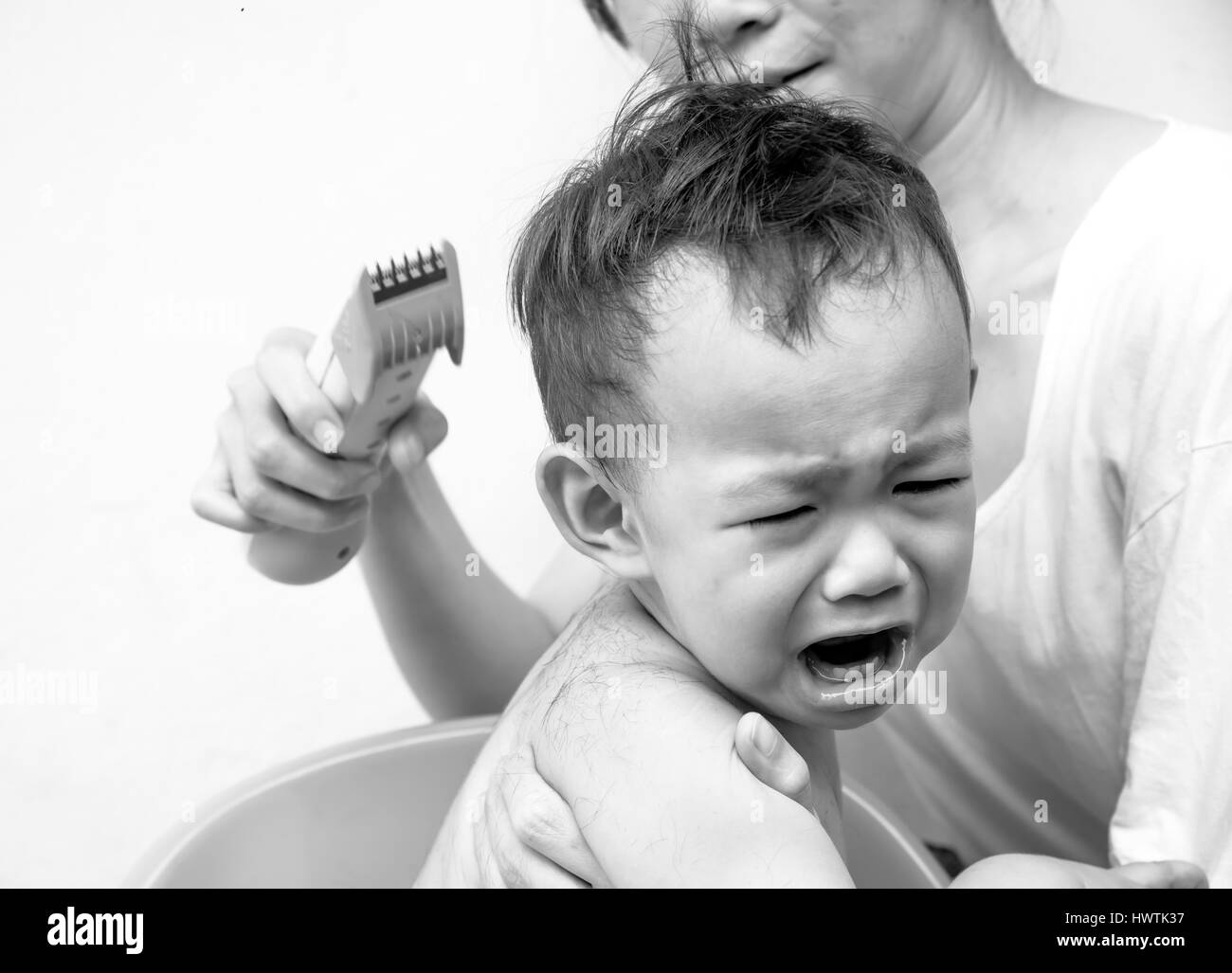 Angst, Thai baby fühlen Angst der Haarschneider als Mutter seine Haare schneiden Stockfoto