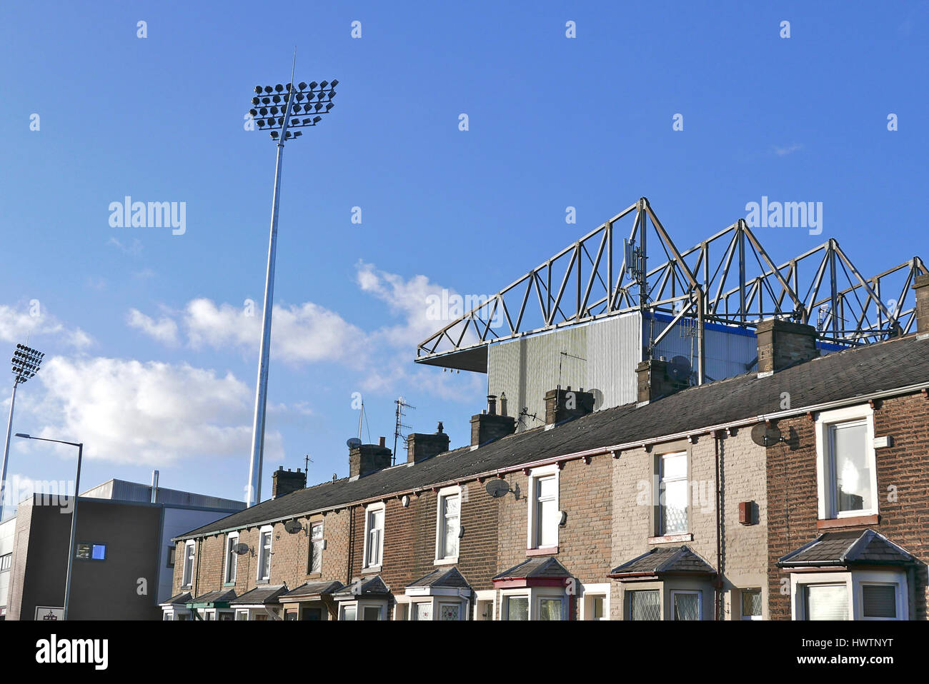 Reihe von Reihenhäusern und Turf Moor, Burnley Football Club, Burnley, Lancashire, UK Stockfoto
