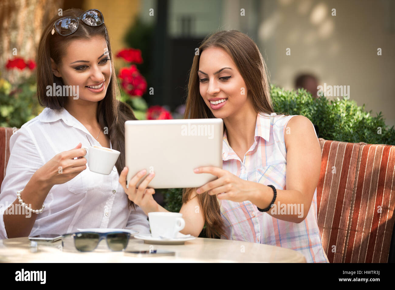 Zwei schöne Mädchen mit Tablet im café Stockfoto