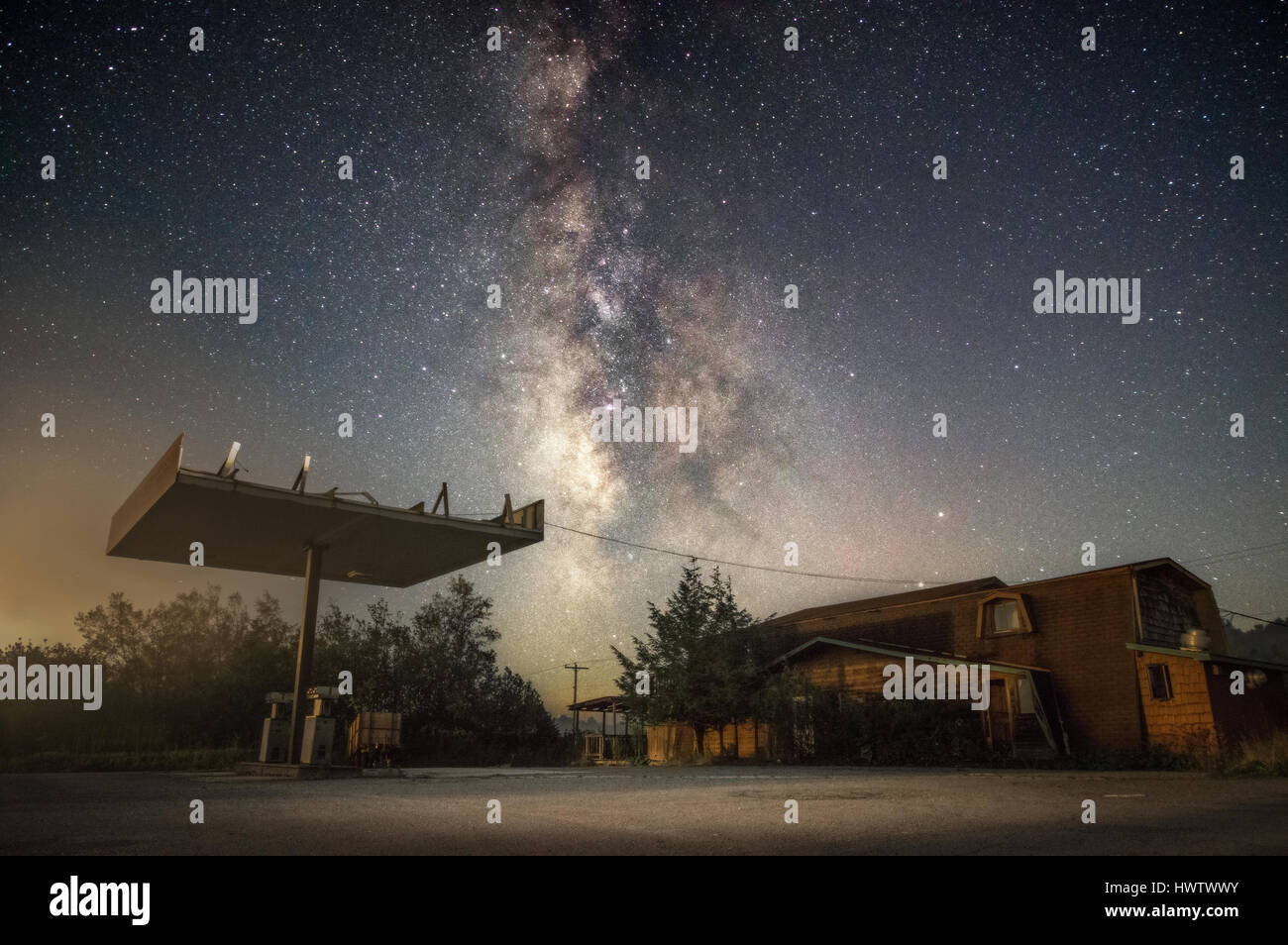 Eine verlassene Tankstelle am Straßenrand steht gegen den Sternenhimmel und die Milchstraße.  Canaan Valley, West Virginia. Stockfoto