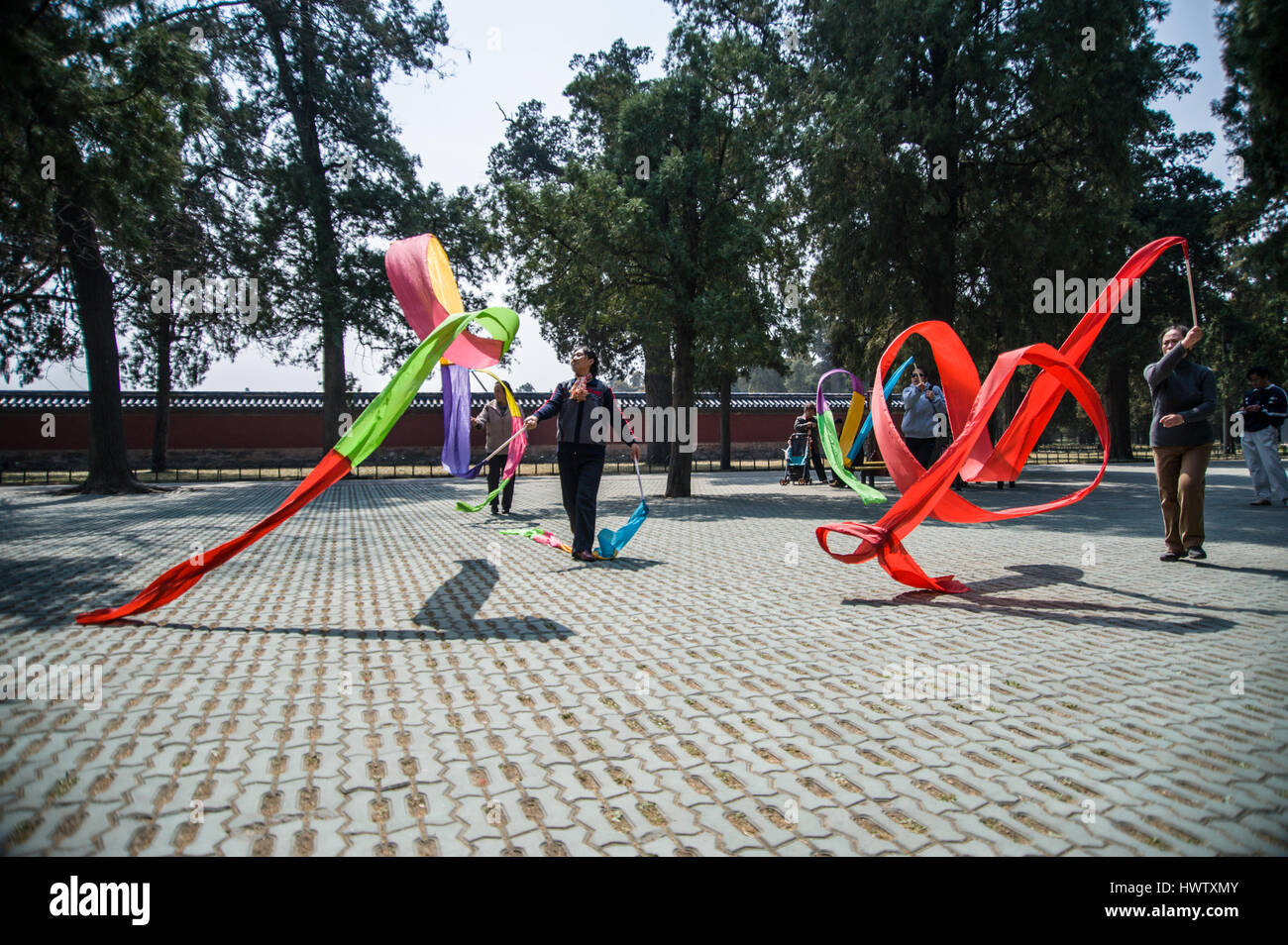 Chinesische Frauen tanzen mit langen und bunten Seidenbändern im Park der Himmelstempel in Peking, China.  Niedrige Horizontalwinkel Stockfoto