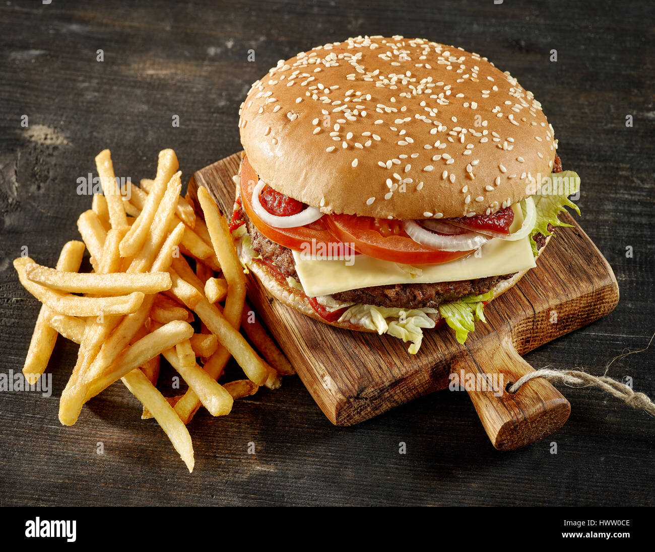frische leckere Burger und Pommes Frites auf dunklen Holztisch Stockfoto