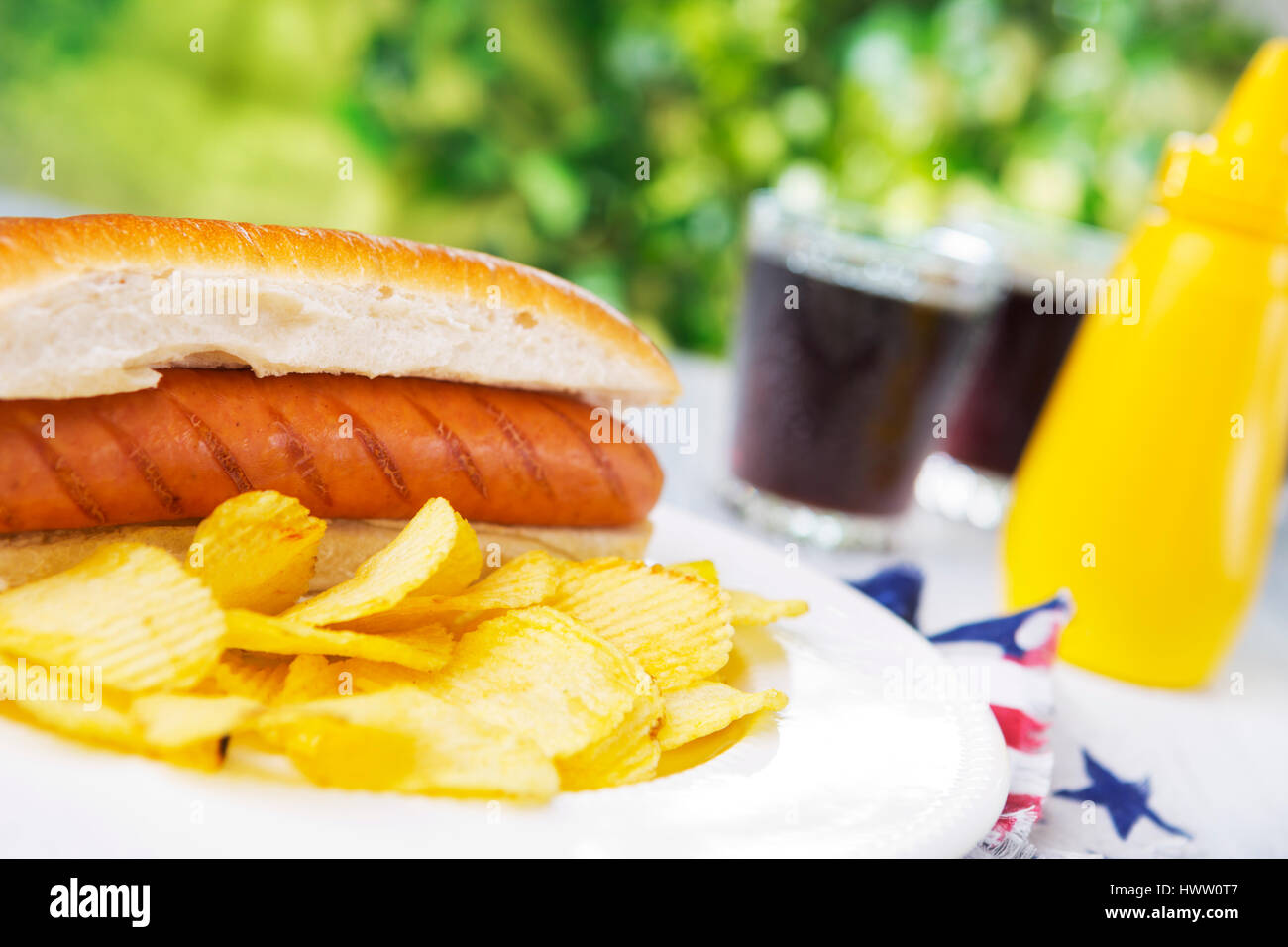 Einen leckeren Hot Dog mit Kartoffel-Chips auf einen Tisch im Freien. Stockfoto