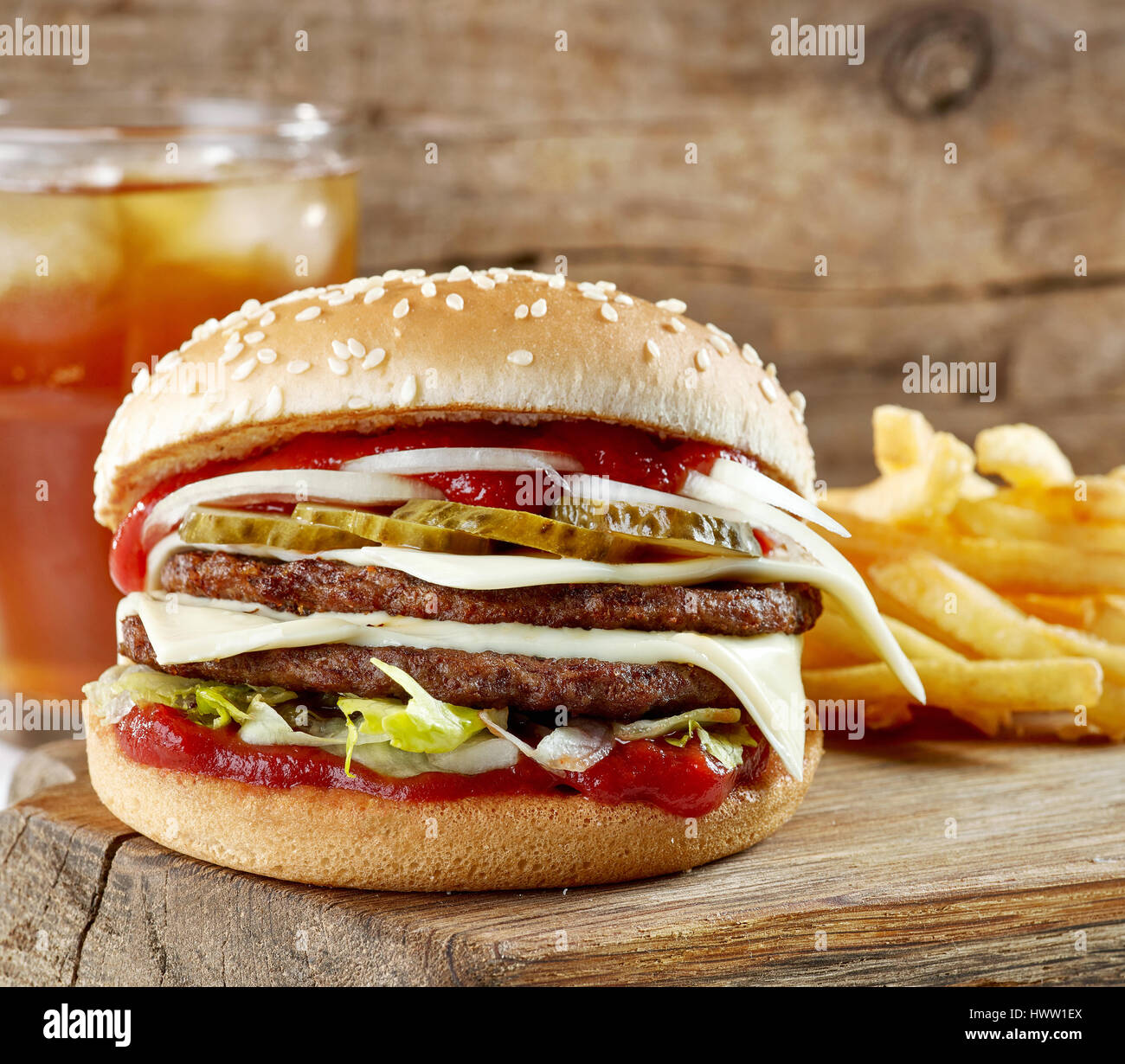 frische leckere Burger und Kartoffeln auf Holzbrett Stockfoto