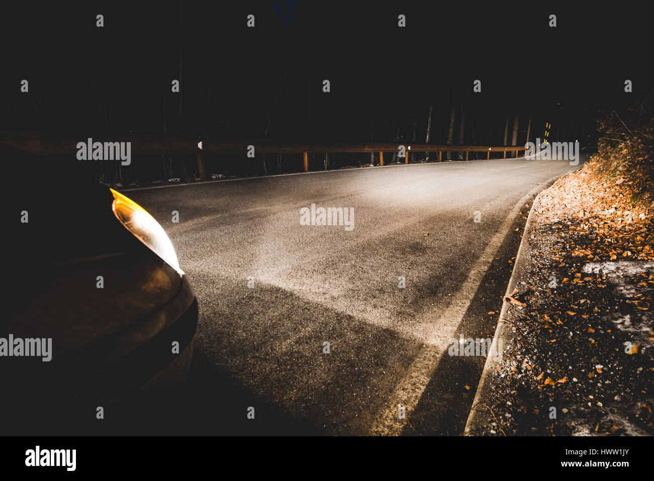 die Scheinwerfer eines Autos auf Bergstraße in der Nacht - Konzept Fahrsicherheit Stockfoto