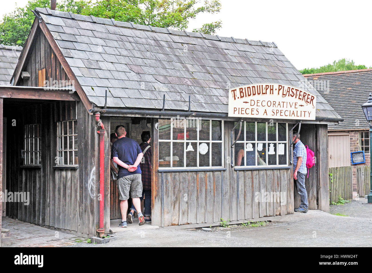 Besucher betreten den Stuckateur-Ladens.  Blists Hill viktorianische Dorf.  Schieferdach. Coalbrookdale Stockfoto
