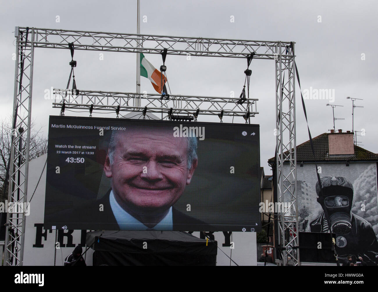 Derry, UK, 23. März 2017. Bildschirm zeigt die Beerdigung von Martin McGuinness an Schlacht des Bogside Wandbild im Hintergrund. Foto von Mickey Rooney/Alamy Live-Nachrichten Stockfoto