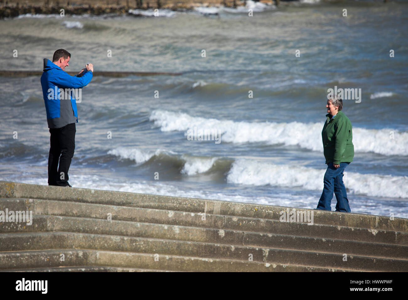 Ein paar Zeit gefunden, um ein Foto zu machen, auf den Slip Weg ins Meer mit Wellen schlagen am Ufer in der beliebten Küstenstadt Stadt Llandudno, Wales Stockfoto