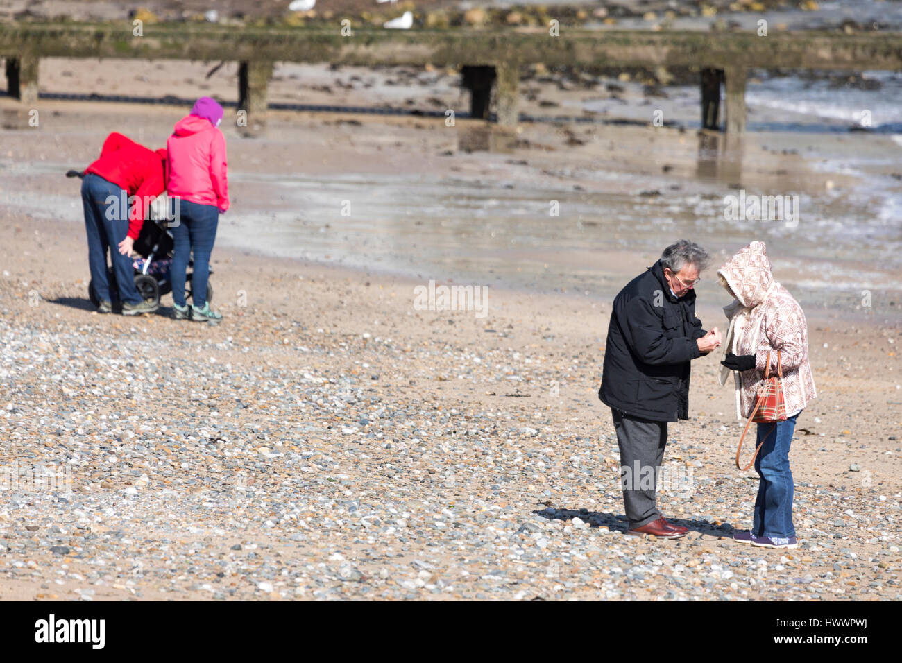 Paar auf der Suche nach Muscheln und prüfen, was sie am Strand des beliebten Badeorts Llandudno, Wales gefunden haben Stockfoto