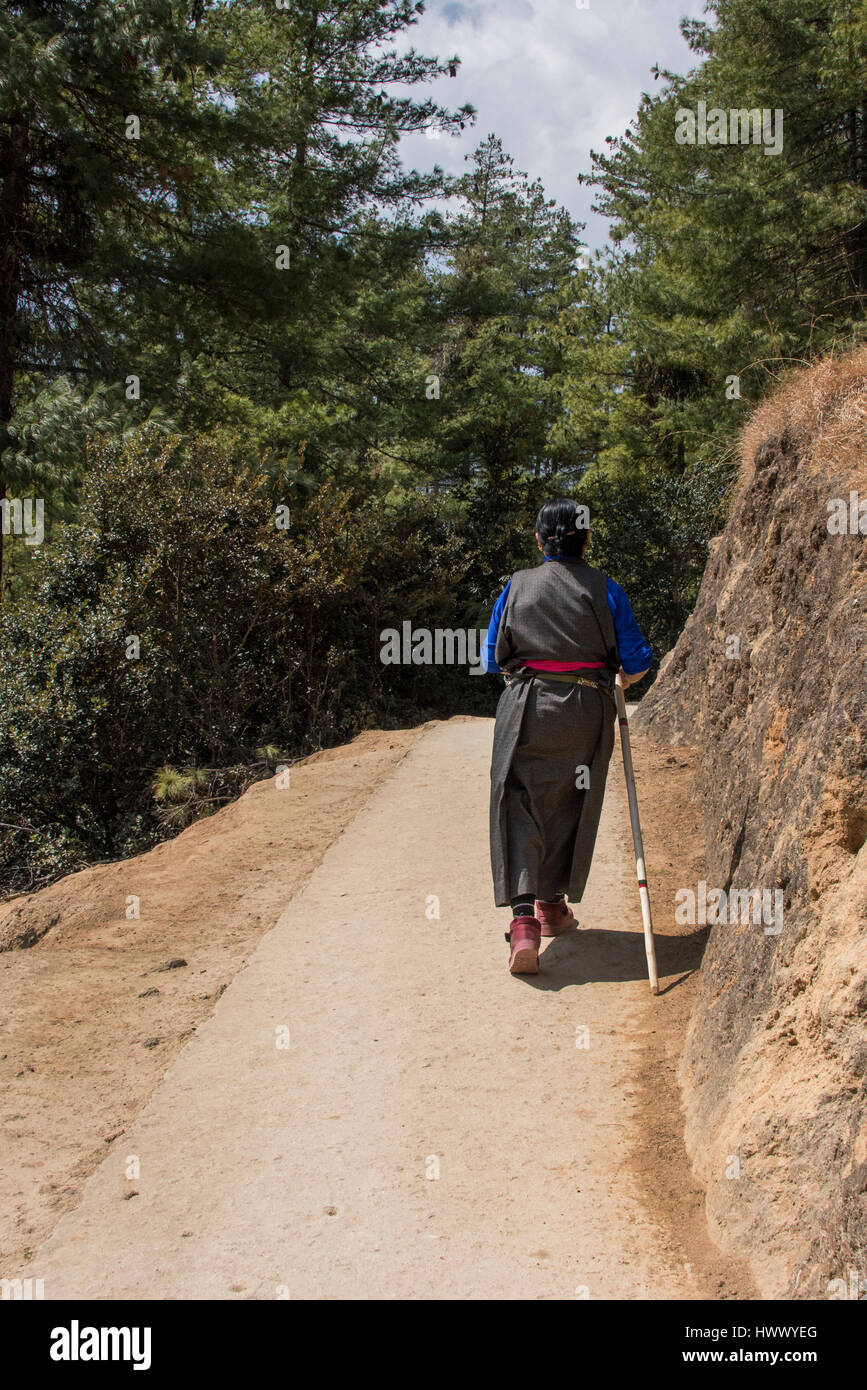 Bhutan, Paro. Wandern bis zu den berühmten Tiger Nest Kloster, Heiligen Himalaya buddhistische Tempelanlage. Lokale Frau Kira (traditionelle nationale dres Stockfoto