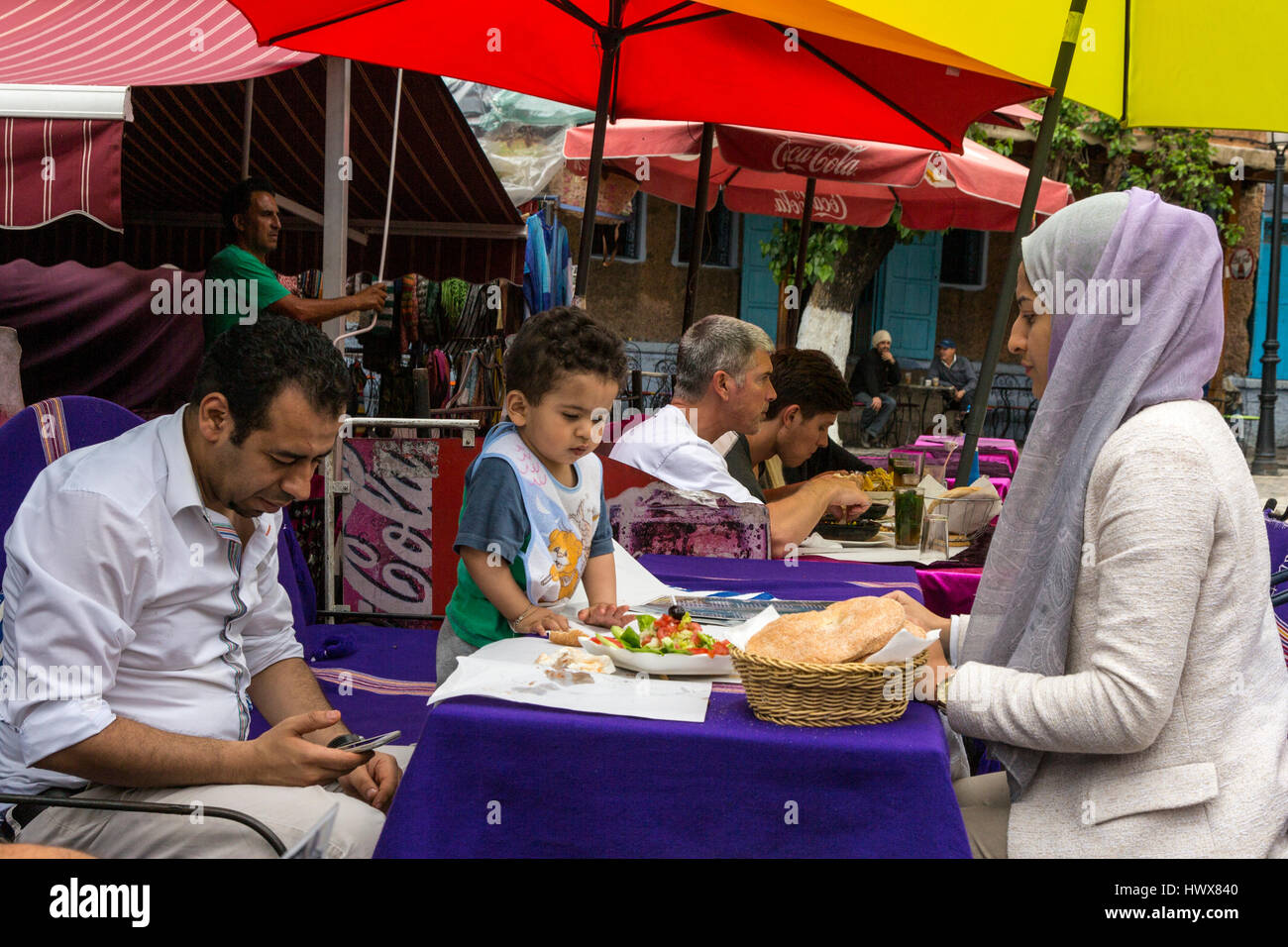 Chefchaouen, Marokko.  Marokkanischen Familie beim Mittagessen im Restaurant Bürgersteig. Stockfoto