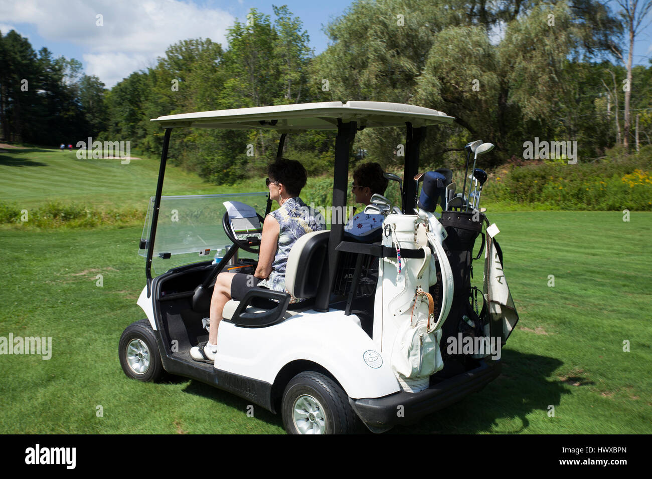 Zwei Frauen warten ihrerseits Golf an einem sonnigen Tag auf dem Golfplatz in Pittsfield, Massachusetts. Stockfoto