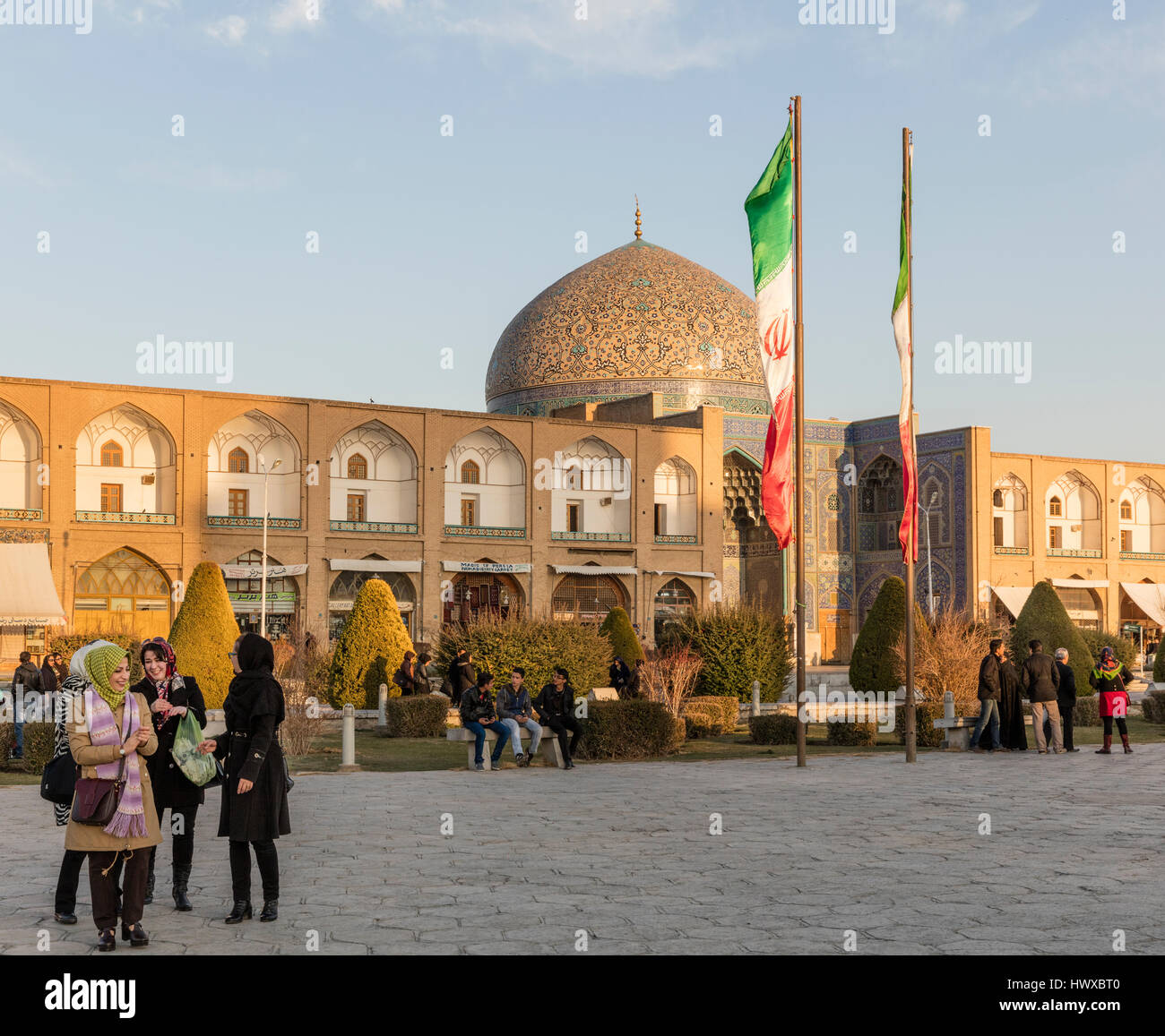 Imam-Platz in Isfahan mit Besuchern, darunter Familien, Tschador gekleidete Frauen und Kuppel des Sheikh Lotfallah Moschee Stockfoto