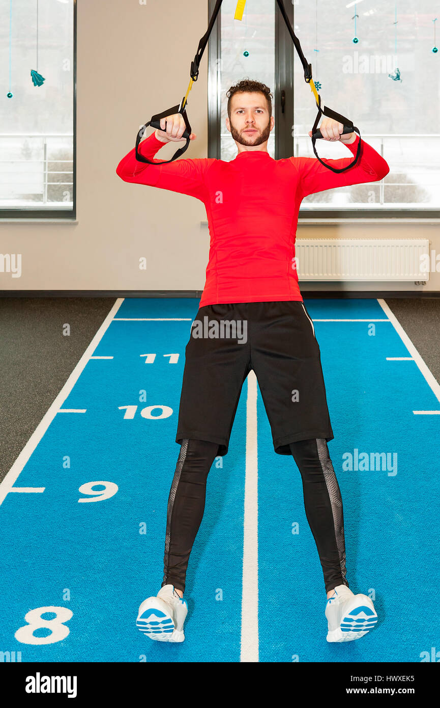 Sportlicher Mann Pull-up mit Fitness Riemen im Fitness-Studio trainieren Stockfoto
