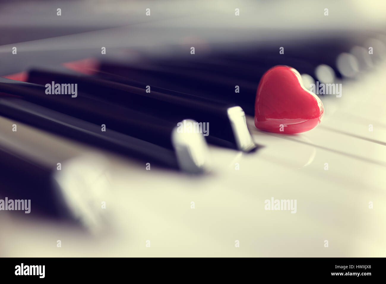 Rotes Herz auf Klavier-Tastatur Tasten Konzept für Liebe zur Musik oder Romantik und Valentinstag Stockfoto