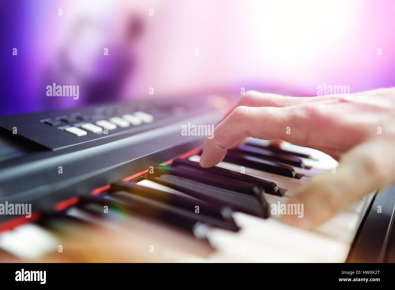 Pianisten Musiker live spielen Tastatur in einer Band mit Saxophonist im Hintergrund Stockfoto