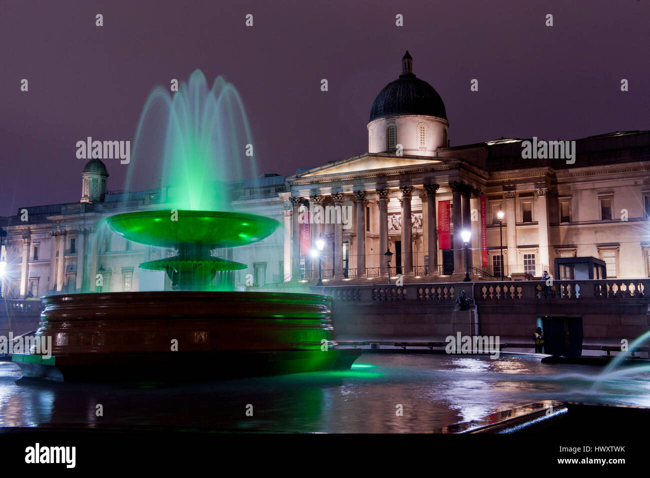 ein grün beleuchteten Brunnen am Trafalgar Square Iin Front der nationalen Galerie beleuchtet Stockfoto