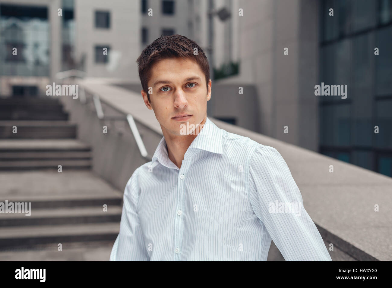 Junger Geschäftsmann Blick in die Kamera und lächelnd Stockfoto