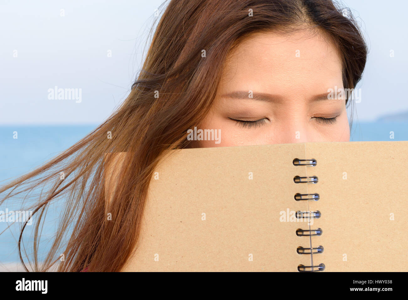 Frauen halten buchen Sie vor ihr Gesicht und Auge schließen Stockfoto