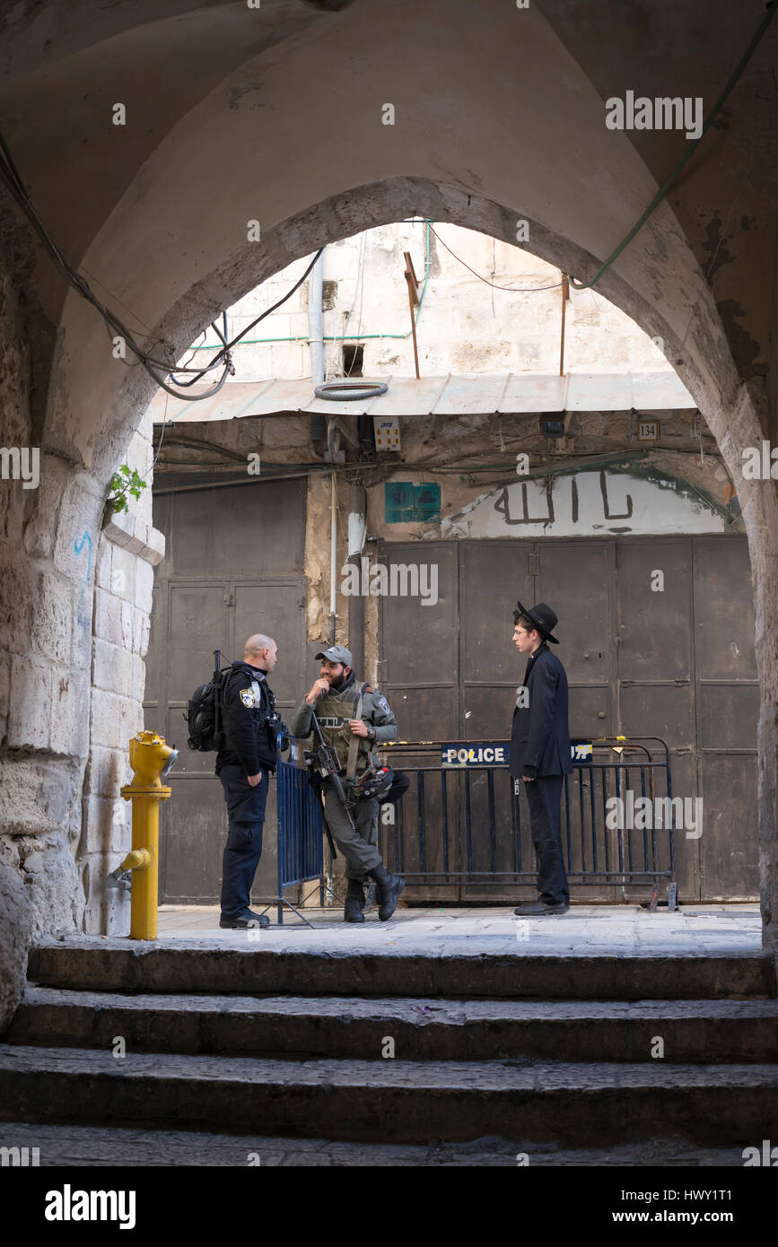 Jerusalem, Israel - 24. Februar 2017: Zwei Polizisten und ein betender orthodoxer Jude auf einen Check-Point zwischen Israel und der palästinensischen Teile der Stadt Stockfoto