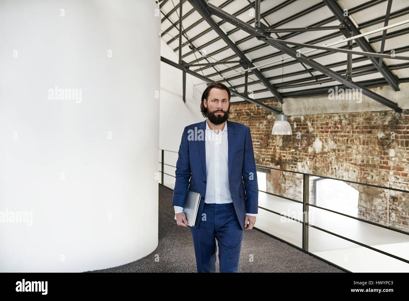 Geschäftsmann zu Fuß im Büro-loft Stockfoto