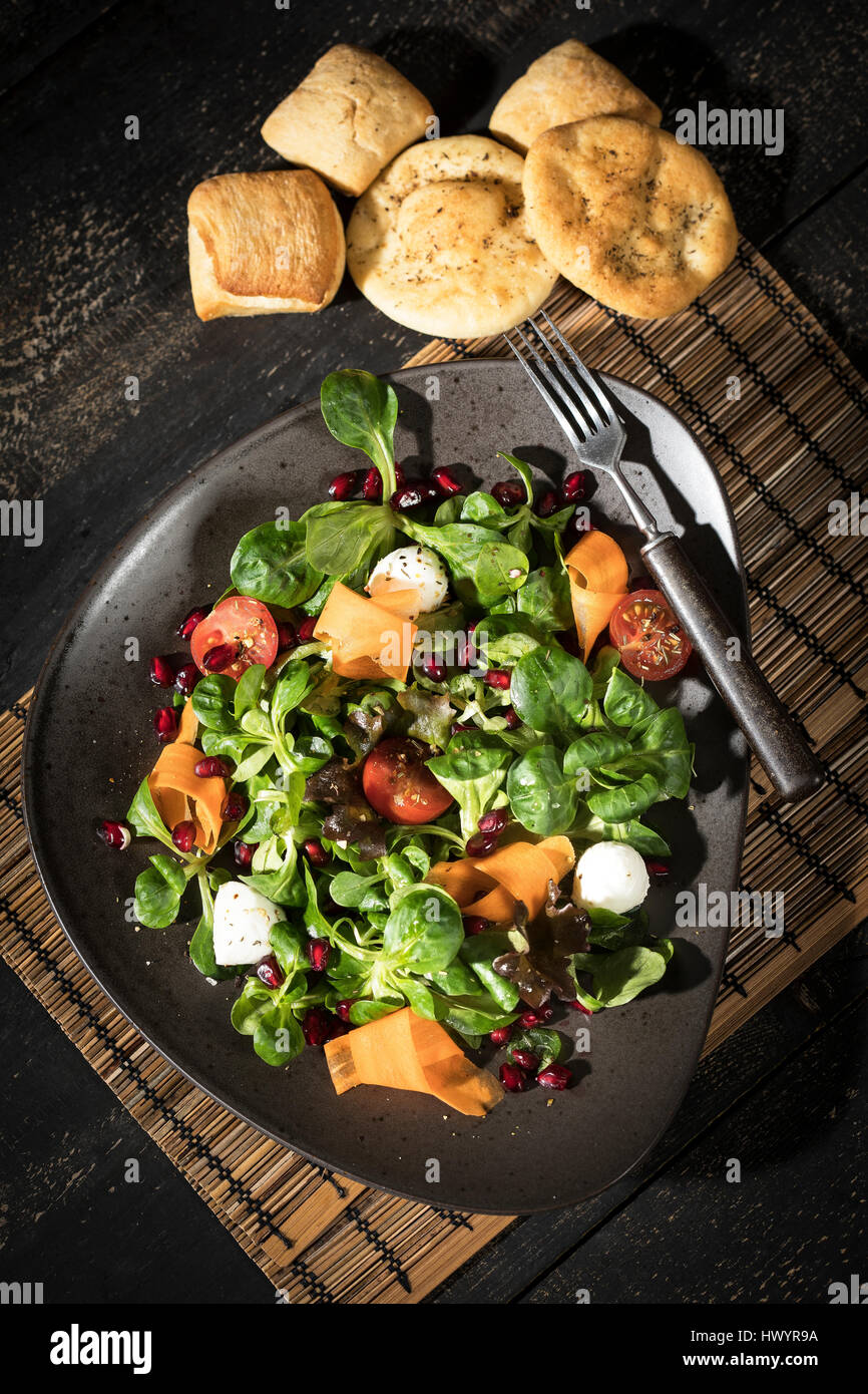 Salatschüssel mit Feldsalat, Karotten, Tomaten, Mozzarella und Granatapfel Samen Stockfoto