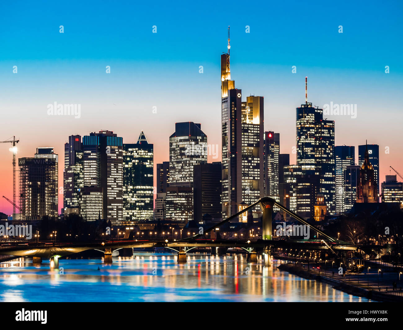 Deutschland, Frankfurt am Main, Blick auf Skyline mit Floesserbruecke und Mains im Vordergrund in der Dämmerung Stockfoto