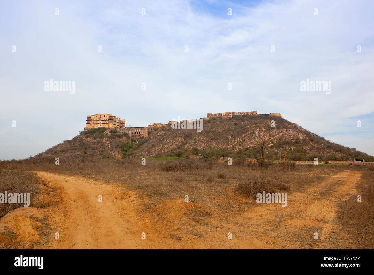 TIJARA-Festung im Norden indischen Bundesstaat Rrajasthan mit Sandpisten und Akazien bei bewölktem Himmel blau Stockfoto
