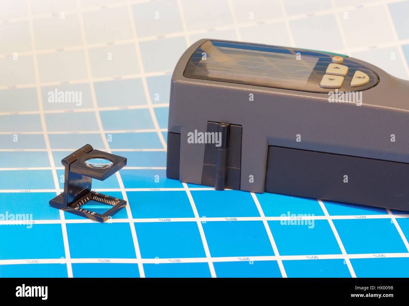 Scan-Densitometer und eine Magnifyer auf einem Blatt von dem Cyan Testausdruck in einem pre-Press-Workshop wenn proofing Stockfoto