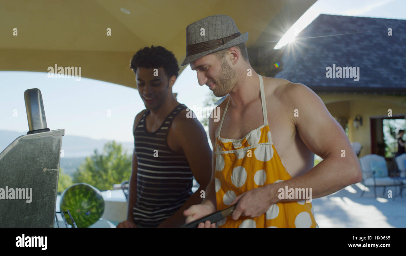Niedrigen Winkel Blick lächelnder Männer kochen Barbecue Grill in sonnigen Hinterhof Stockfoto