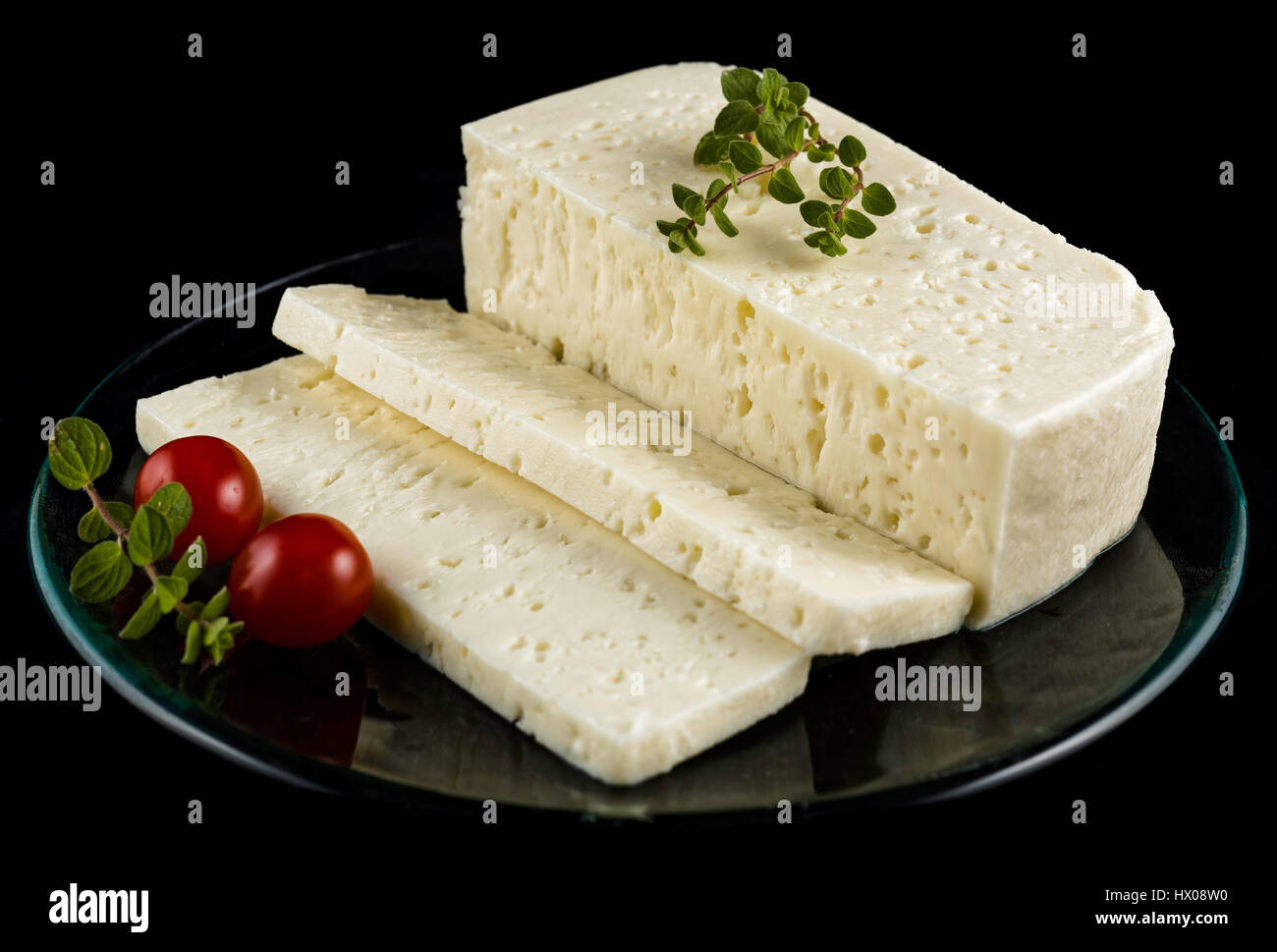 Käsescheiben traditionelle Sfella des Peloponnes, Griechenland, auf Teller mit kleinen Tomaten und oregano Stockfoto