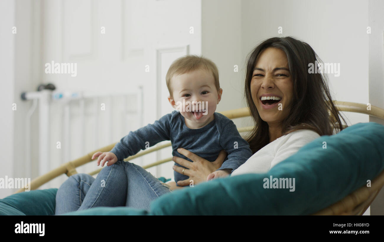 Niedrigen Winkel selektiven Fokus Porträt von Mutter und Baby Sohn posieren und sitzen auf Stuhl Stockfoto