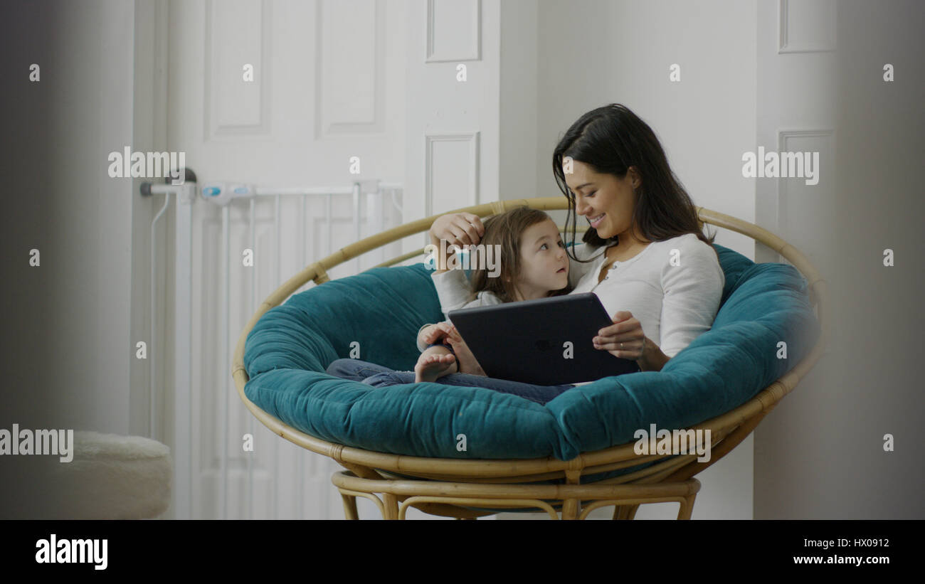 Selektiven Fokus Blick auf Mutter und Tochter mit digital-Tablette und sitzen auf Stuhl Stockfoto