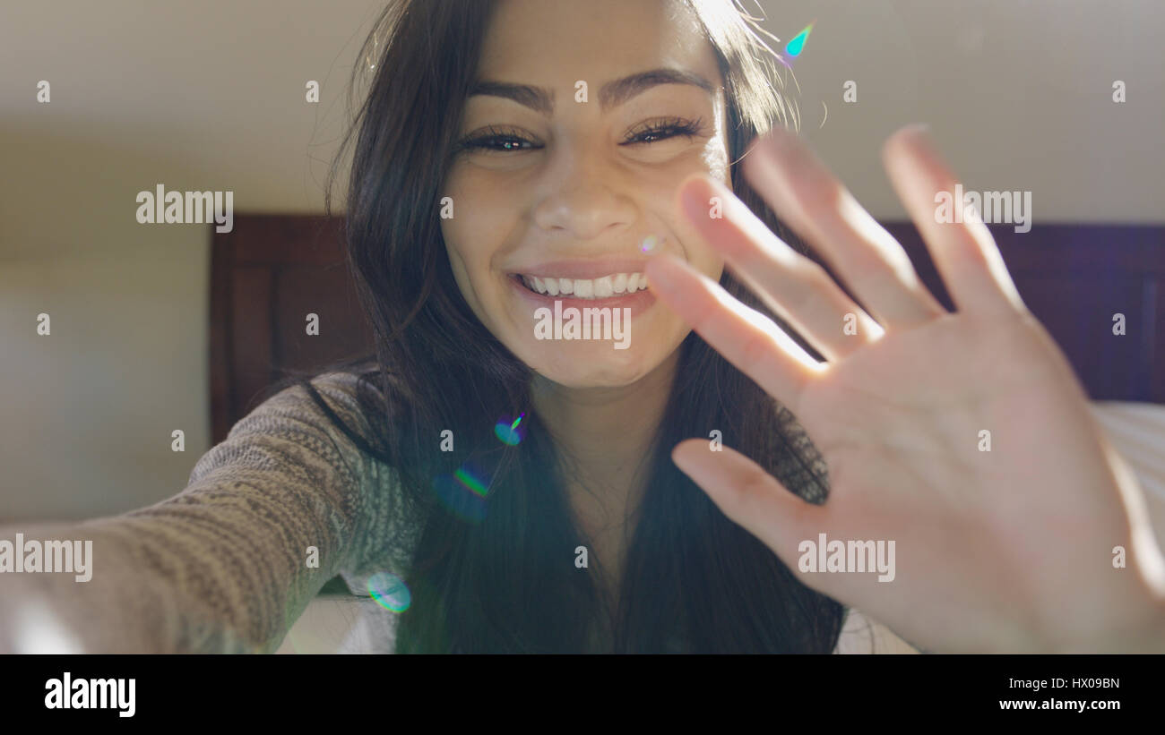 Selektiven Fokus Porträt der lächelnde Frau posiert und winken auf Bett Stockfoto