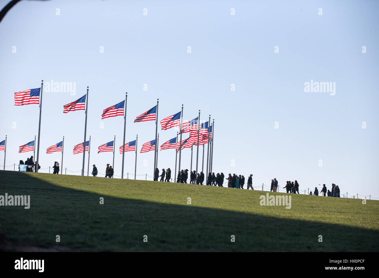 Touristen gehen das Washington Monument auf der National Mall in Washington, D.C. 22. März 2017. Stockfoto