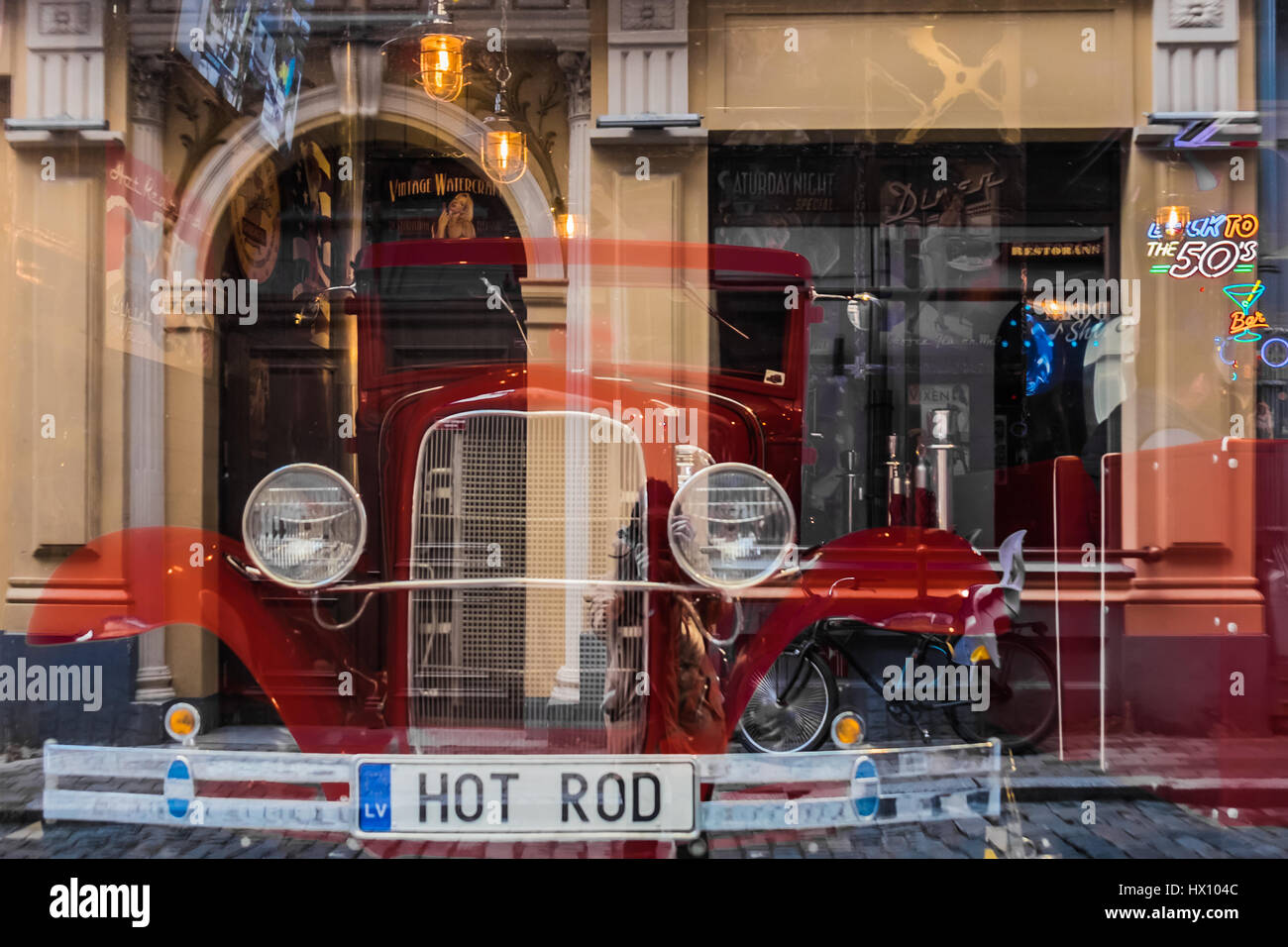 Riga, Lettland - 20. März 2017: Hot Rod in american Vintage Bar mit Photorgapher und Street Reflexionen Stockfoto