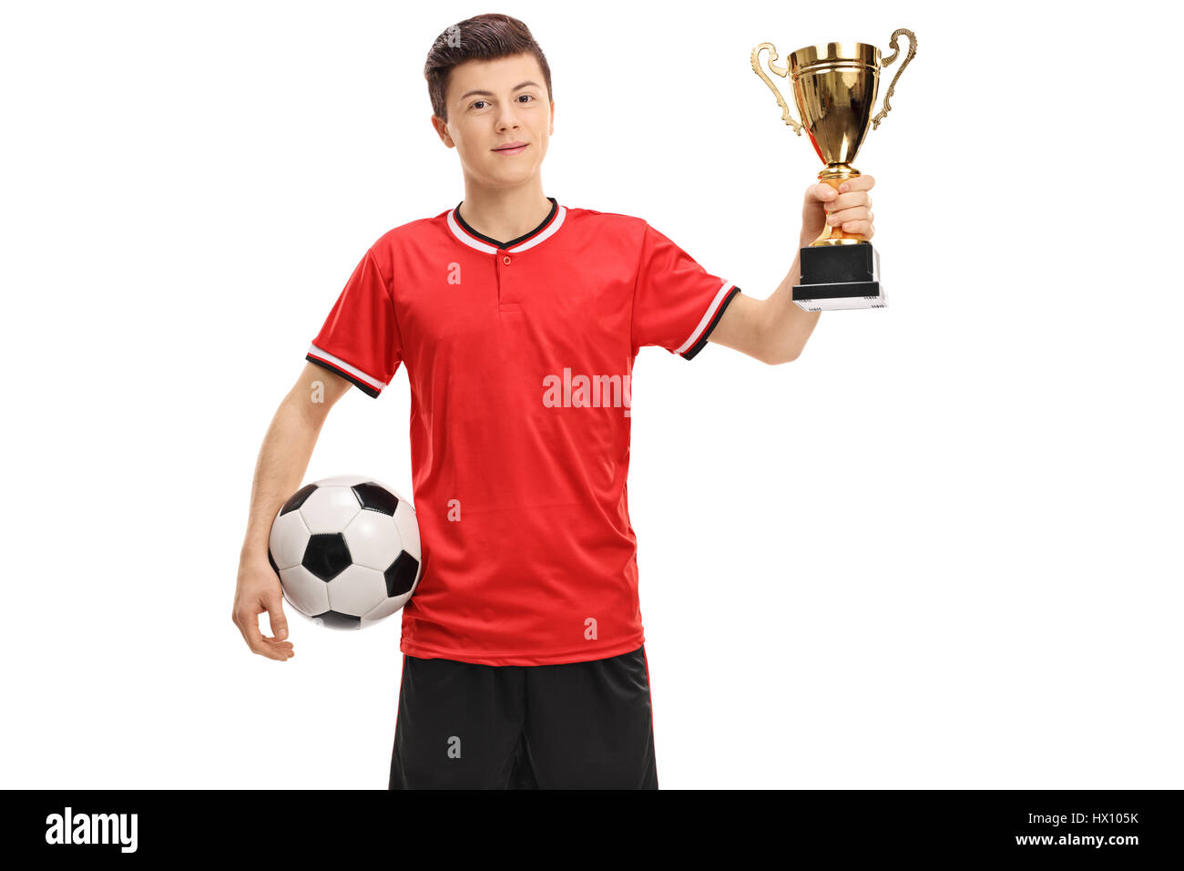 Teenager Fußballspieler mit einem Fußball und eine goldene Trophäe isoliert auf weißem Hintergrund Stockfoto