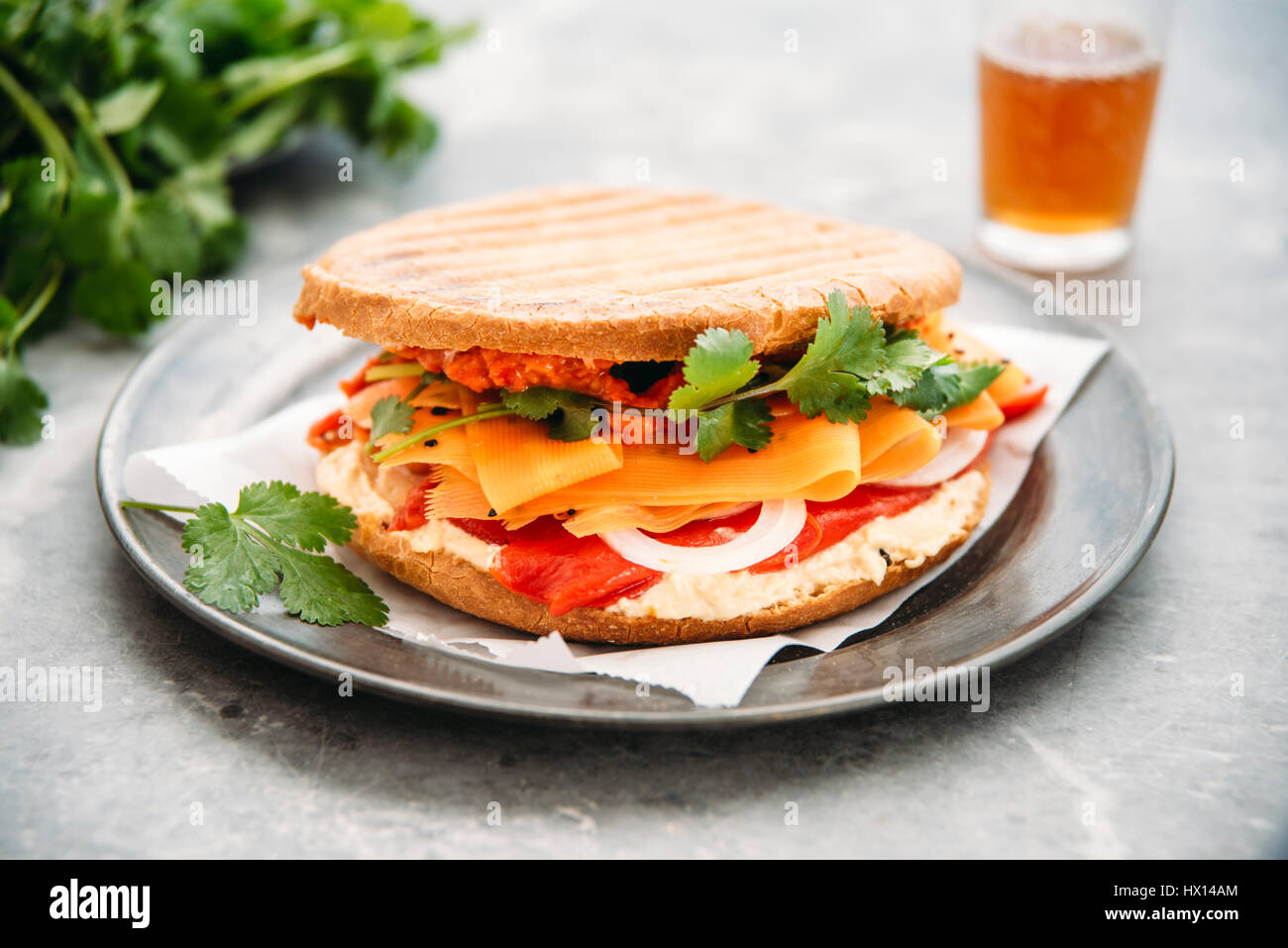Marokkanischen Stil Sandwich mit Hummus, gegrilltem Paprika, Zwiebeln, Karotten, Koriander, Ajvar, Schwarzkümmel Stockfoto
