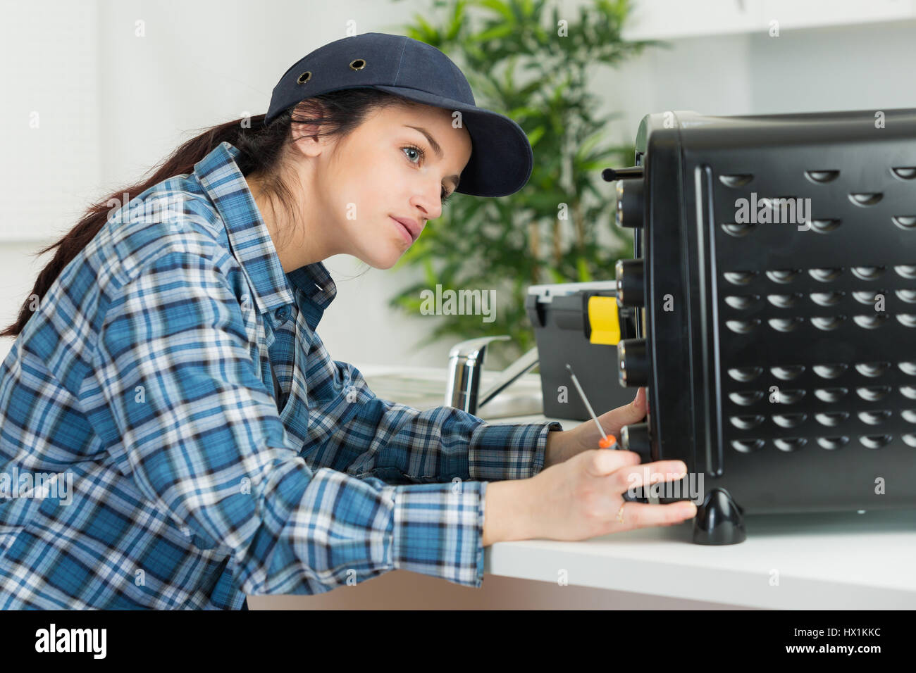 Weibliche Elektriker arbeiten am Gerät Stockfoto