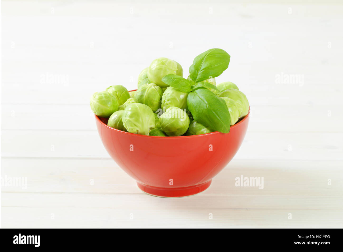 Schüssel mit rohem Rosenkohl auf weißem Hintergrund Stockfoto