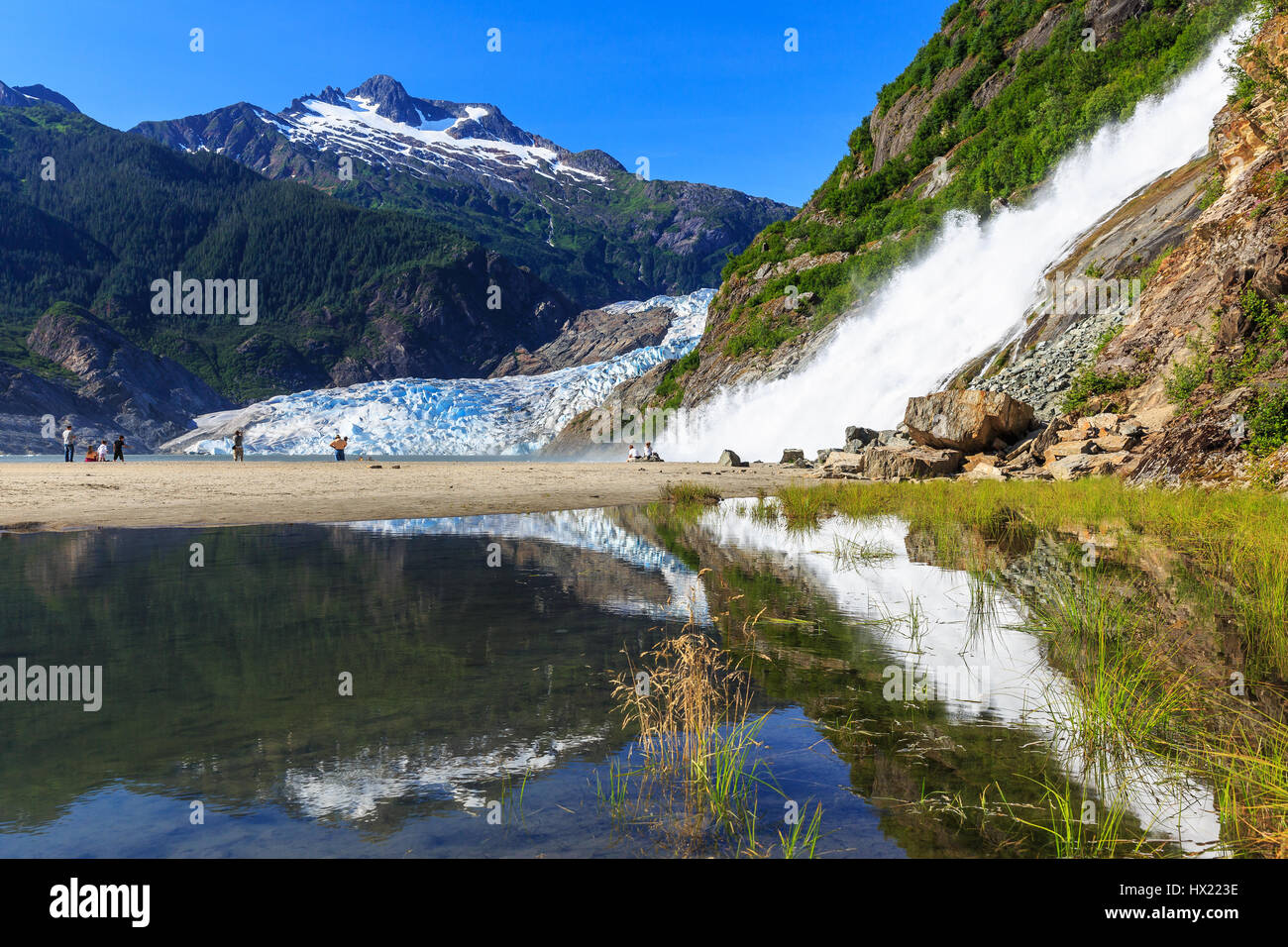 Juneau, Alaska. Mendenhall Gletscher Aussichtspunkt mit Spiegelbild im See und Wasserfall. Stockfoto