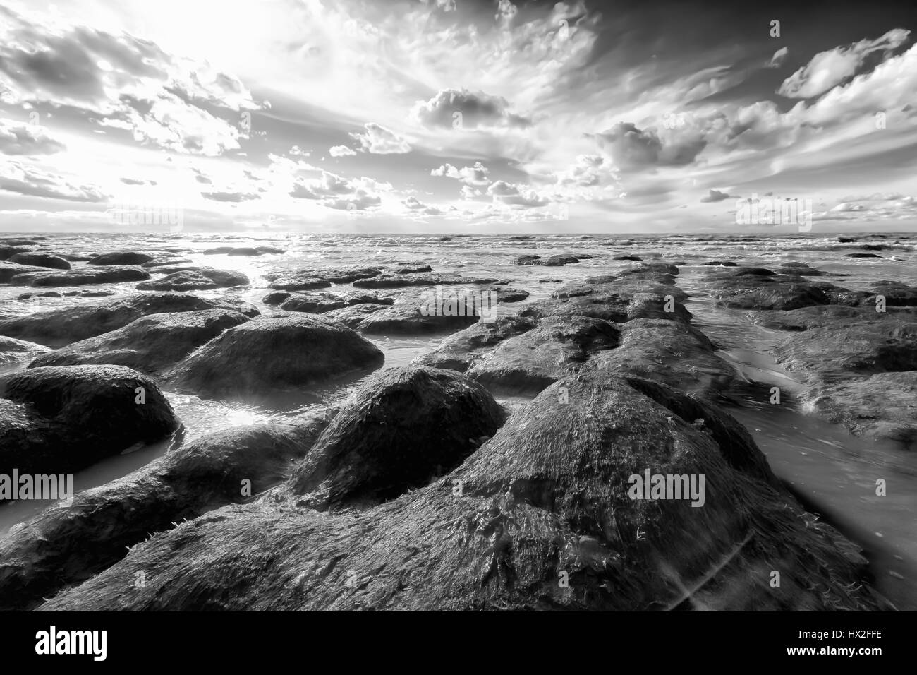 Norfolk UK zerklüfteten Strand Küste mit atemberaubenden Wolken und Felsen bei Sonnenuntergang. Stockfoto